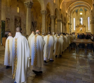 Priests in solemn vestments enter the Cathedral di San Cerbone for Mass on Holy Thursday
