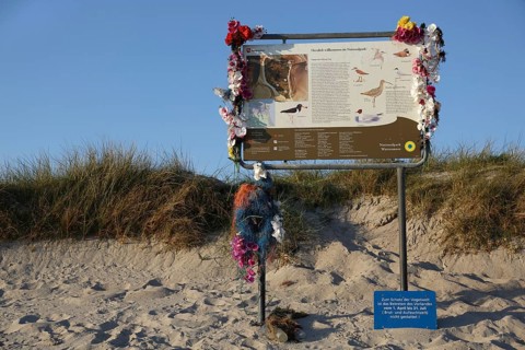 Tourist information board decorated with marine litter on the island of Minsener Oog