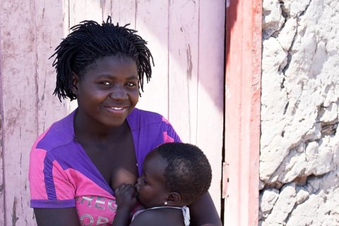 Breastfeeding mother with child in a village near the Tsodilo Hills