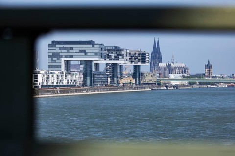View of the city of Cologne and the Rhine through the railing of the South Bridge with Rheinauhafen