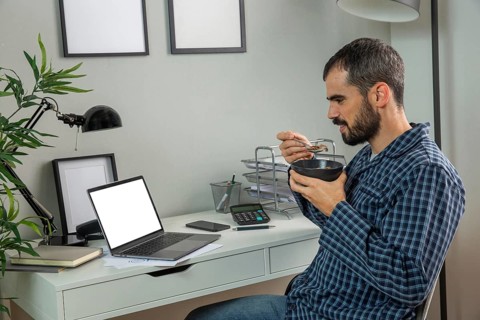 Man having breakfast while working from home