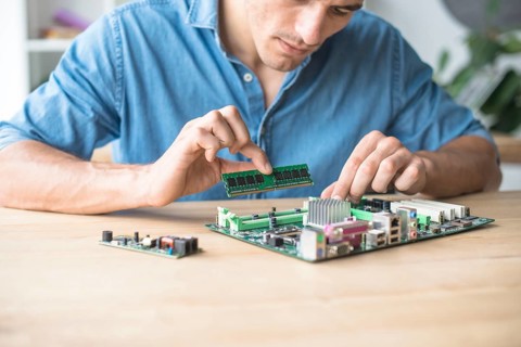 Technician inserting ram socket computer motherboard