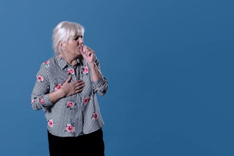 Elderly woman is coughing