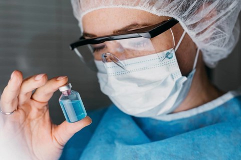 Doctor holding vaccine bottle