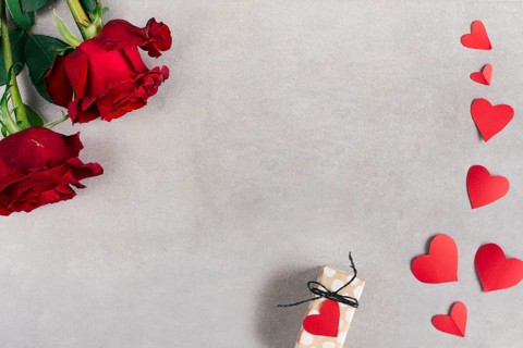 Paper hearts near present box flowers