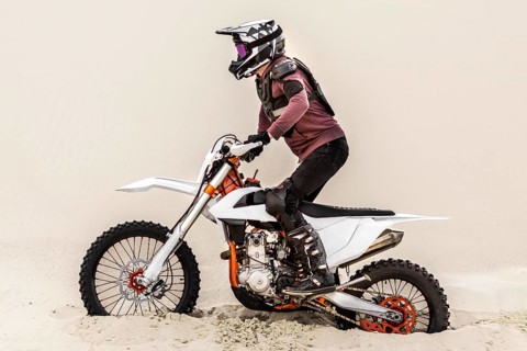 Stylish man riding motorbike desert