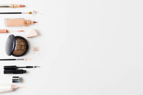 Makeup products arranged gray background