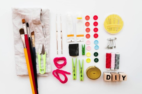 Diy equipment paintbrush clothespin needle safety pins acrylic paint tube buttons diy blocks measuring tape isolated white backdrop