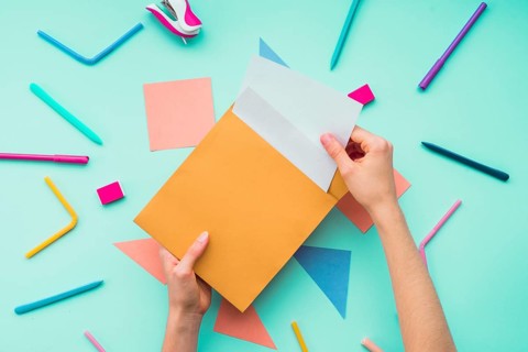 Female hand removing card from envelope stationery accessories