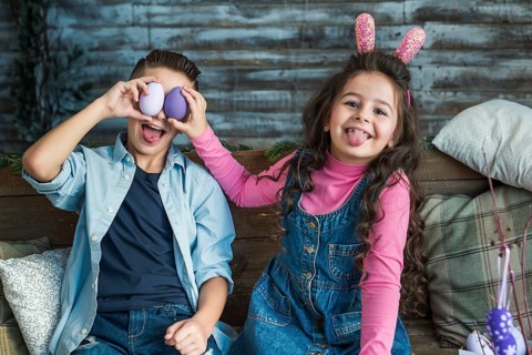 Girl boy with easter eggs making faces