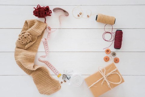 Knitted hosiery wool measuring tape spool button wrapped gift box wooden desk
