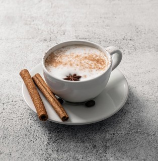 High angle coffee cup with cinnamon sticks star anise