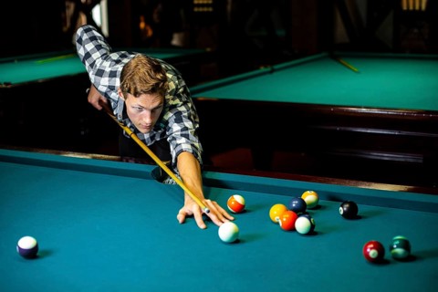 Medium shot guy with pool cue billiard table