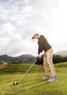Side view man playing golf field with club copy space
