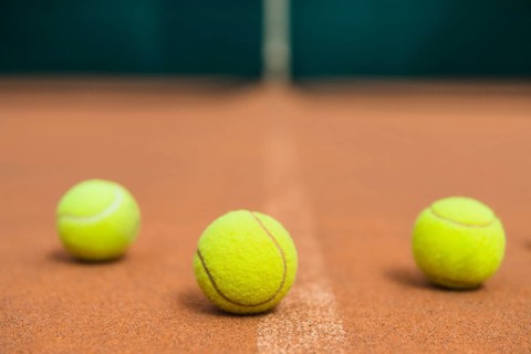 Three green tennis balls tennis court