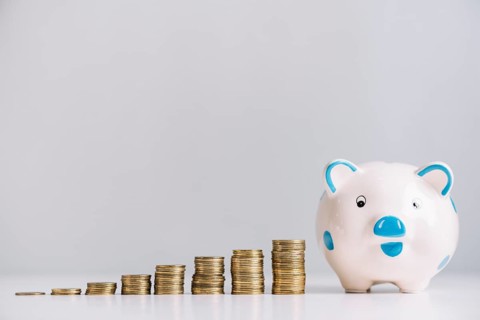 Piggybank increasing stacked coins reflective desk