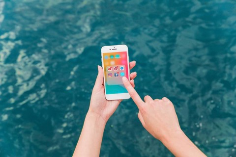 Woman s hand using cellphone with social media notifications screen