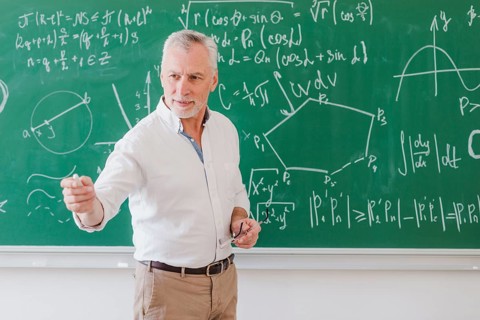 Sociable male teacher standing blackboard pointing by hand