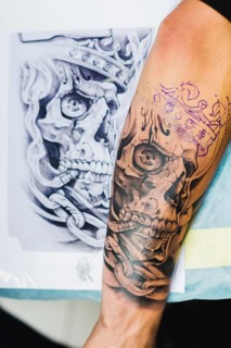 Arm with tattoo near sketch