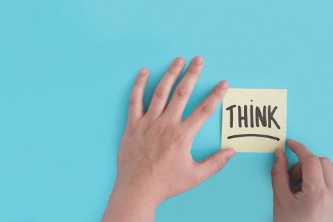 Hand sticking think adhesive note blue background