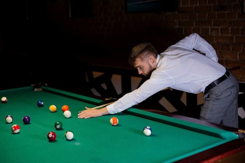 Side view guy with pool cue