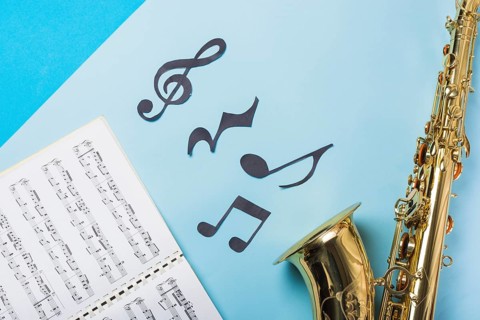 Musical notebook golden saxophones blue backdrop