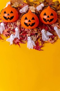 Overhead view of orange Halloween pumpkins on a background of yellow