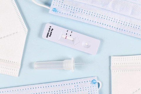 Corona virus rapid antigen test with negative result and medical face masks on blue background