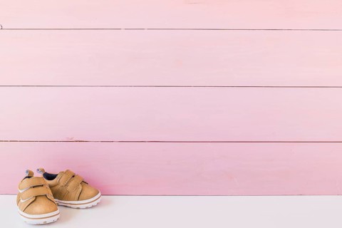Newborn concept with shoes space wooden surface