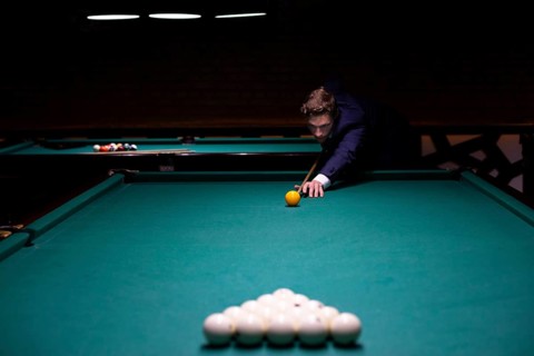 Medium shot man suit playing billiard
