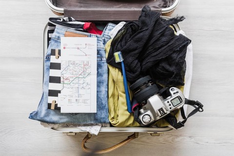 Top view female s travelling bag with camera brush map