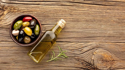 Assortment colorful olives with oil bottle copy space