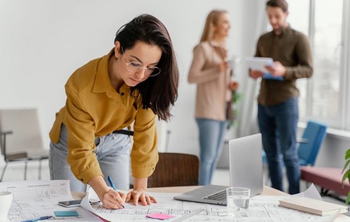 Businesswoman working while her teammates are talking