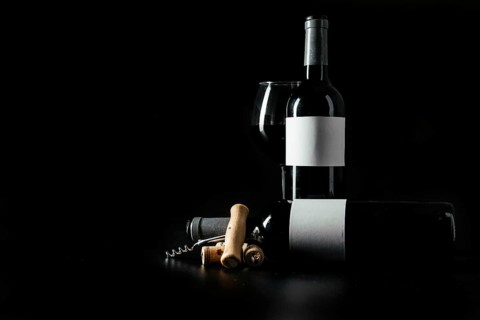 Corkscrew corks near bottles wineglass