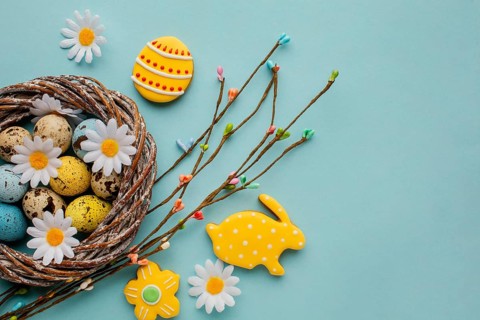 Flat lay easter eggs basket with chamomile flowers