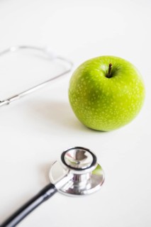 Green apple stethoscope white background