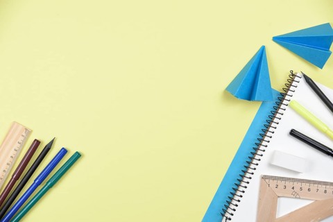 Office stationaries folded paper yellow background