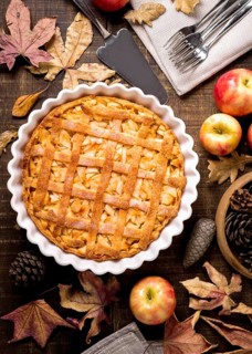 Top view thanksgiving apple pie with autumn leaves pine cones