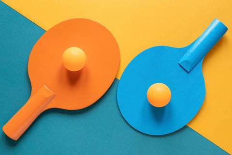 Top view two ping pong paddles with new balls