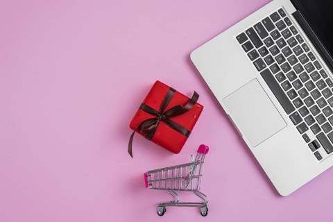 Toy shopping trolley present near laptop keyboard