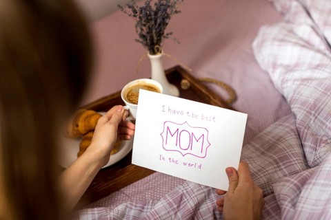 Woman holding greeting card coffee cup tray