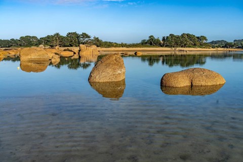 The rocks of the pink granite coast Cote de Granit Rose at the Baie de Sainte Anne near Tregastel