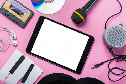 Cassette tape cd earphone vinyl record microphone speaker paper piano keys around digital tablet pink background