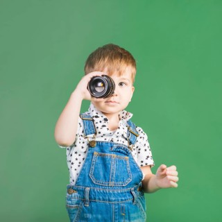 Boy holding camera lens eye