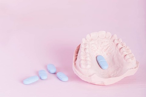 Dental model plaster cast pills pink background