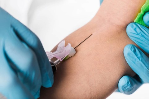 Close up doctor taking blood sample from sick person