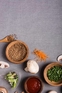 Wooden bowl spring onion coriander seeds sauce mushroom grated carrot grey linen tablecloth