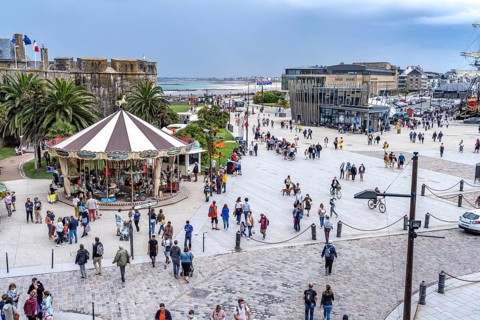 Square in front of the city gate Porte St Vincent with carousel Manege and tourist information in Saint Malo