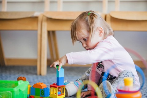 Girl stacking toys playroom