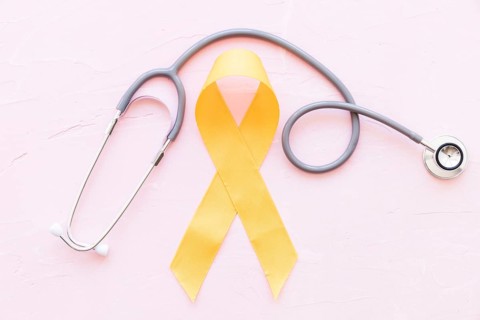 Sarcoma bone cancer yellow ribbon with stethoscope pink background